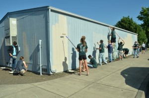 Volunteers paint the mobile classroom at Periwinkle