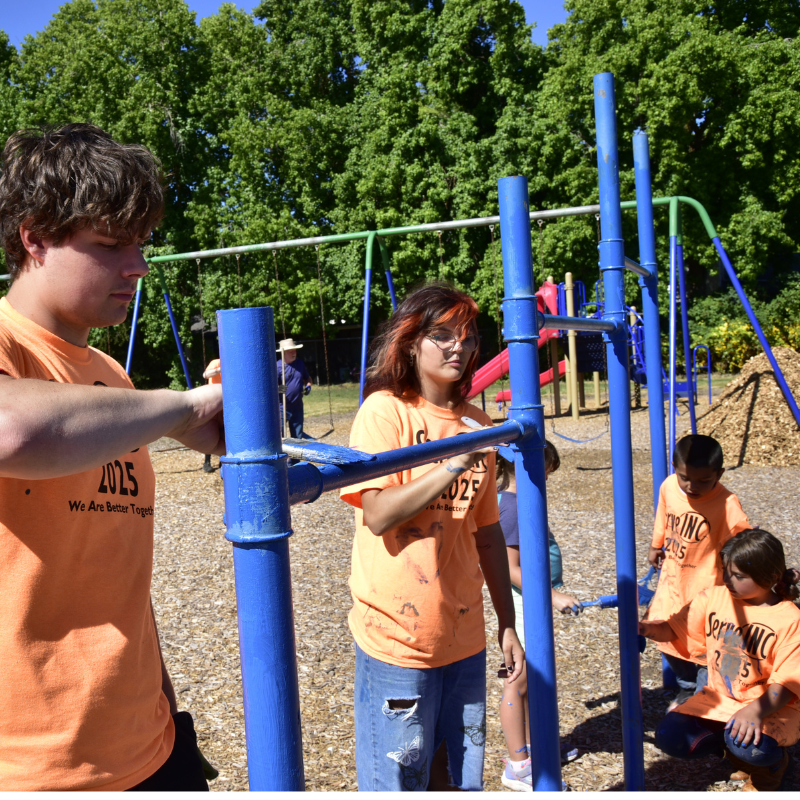 Pictured: Painters working together to repaint the playground equipment during the 2025 Day of Service.